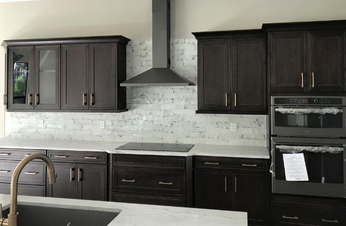 dark wood cabinets with stone countertops and custom subway tile marble backsplash tile